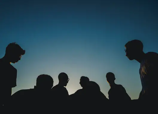 People in silhouette against a dark blue background